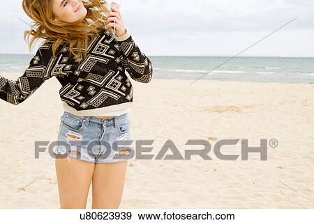 Young woman dancing to MP3 player on beach View Large Photo Image Stock Photo - Young woman dancing to MP3 player on beach. Fotosearch