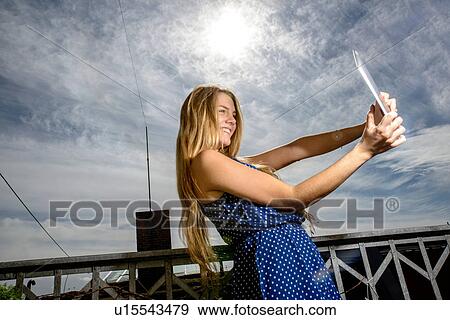 Young woman holding digital tablet View Large Photo Image Stock Photo - Young woman holding digital tablet. Fotosearch