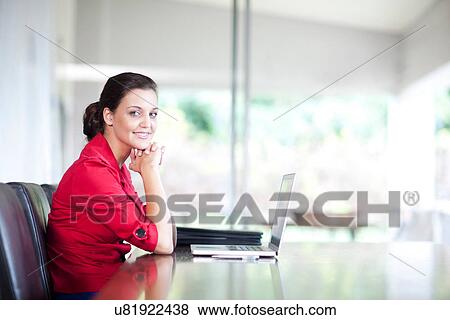 Young woman in office with laptop View Large Photo Image Stock Photo - Young woman in office with laptop. Fotosearch