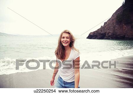 Picture - Young woman on beach, smiling. Fotosearch