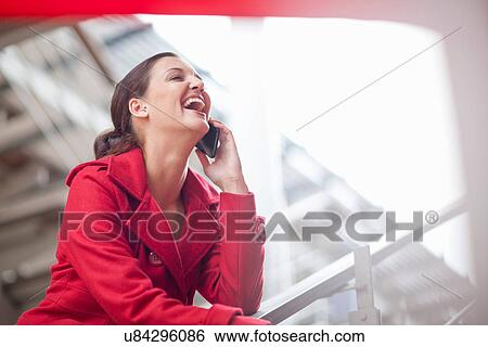 Young woman on cellphone in shopping mall View Large Photo Image Stock Photograph - Young woman on cellphone in shopping mall. Fotosearch