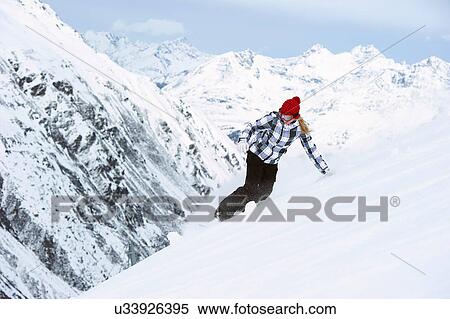 Stock Photography - Young woman snowboarding. Fotosearch