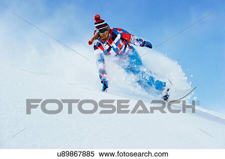 Stock Photography - Young woman snowboarding. Fotosearch