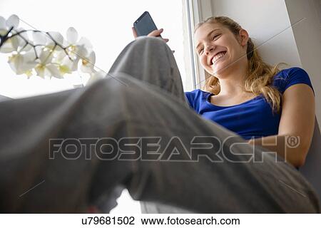 Young woman using cell phone, low angle View Large Photo Image Stock Image - Young woman using cell phone, low angle. Fotosearch