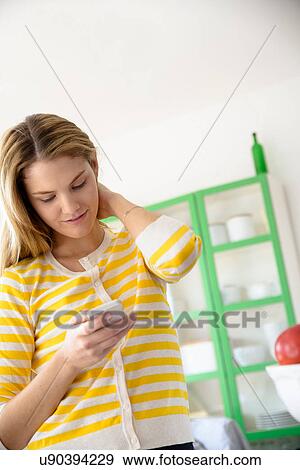 Young woman using smartphone View Large Photo Image Stock Photo - Young woman using smartphone. Fotosearch