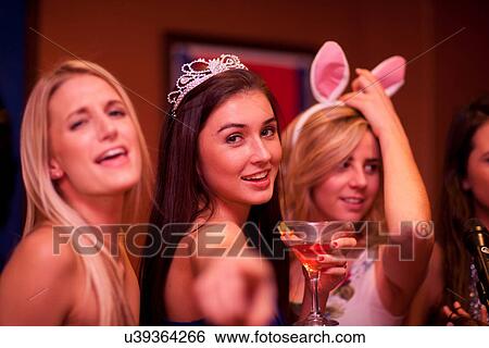 Stock Photograph - Young woman wearing tiara holding cocktail. Fotosearch