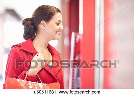 Stock Image - Young woman window shopping. Fotosearch