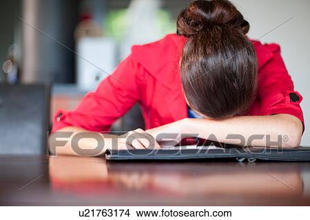 Young woman with head on desk View Large Photo Image Picture - Young woman with head on desk. Fotosearch