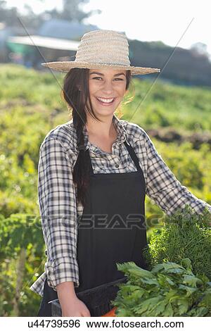 Young woman with vegetables grown at farm View Large Photo Image Stock Photograph - Young woman with vegetables grown at farm. Fotosearch