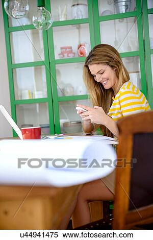 Young woman working from home using cell phone View Large Photo Image Stock Photography - Young woman working from home using cell phone. Fotosearch