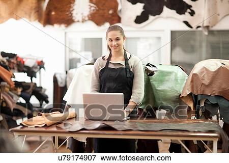 Stock Photo - Young woman working in a leather workshop. Fotosearch