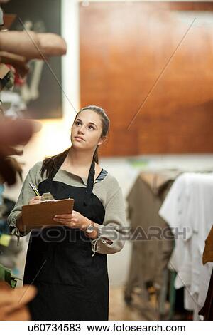 Young woman working in leather stockroom View Large Photo Image Stock Image - Young woman working in leather stockroom. Fotosearch