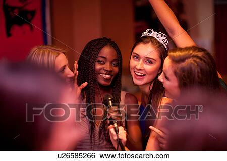 Young women singing in karaoke bar View Large Photo Image Stock Photograph - Young women singing in karaoke bar. Fotosearch