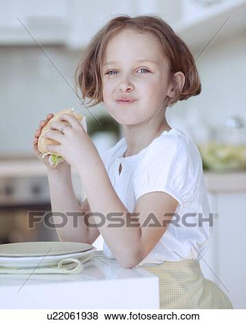 Beautiful Young Girl eating sandwich View Large Photo Image Stock Photo - Beautiful Young Girl eating sandwich . Fotosearch