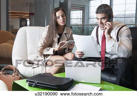 Businessman and businesswoman at meeting with laptop and tablet View Large Photo Image Stock Image - Businessman and businesswoman at meeting with laptop and tablet. Fotosearch