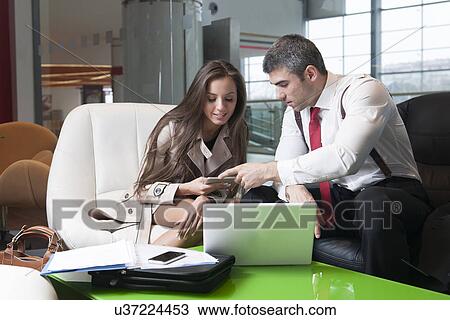 Businessman and businesswoman at meeting with laptop and tablet View Large Photo Image Stock Image - Businessman and businesswoman at meeting with laptop and tablet. Fotosearch