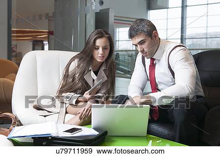 Stock Photo - Businessman and businesswoman at meeting with laptop. Fotosearch