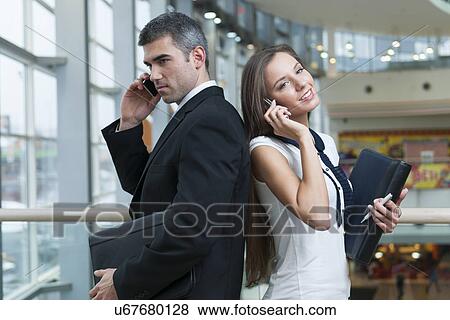 Businessman and Businesswoman back to back on mobile phones View Large Photo Image Stock Photo - Businessman and Businesswoman back to back on mobile phones. Fotosearch