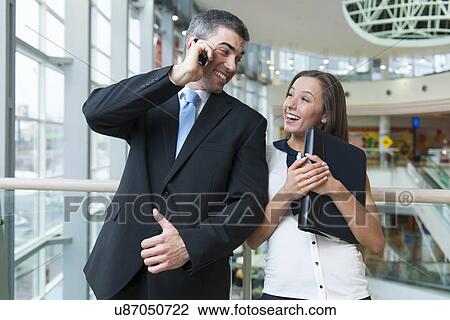 Businessman and businesswoman on mobile phones View Large Photo Image Stock Image - Businessman and businesswoman on mobile phones. Fotosearch