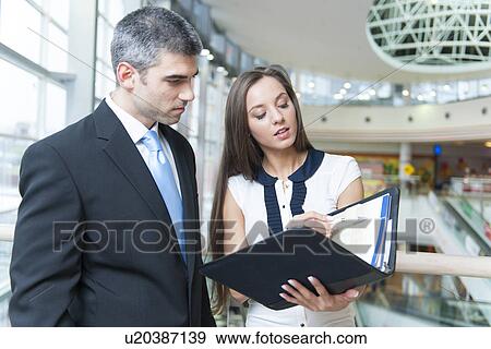 Businessman and woman discussing work View Large Photo Image Stock Photo - Businessman and woman discussing work. Fotosearch
