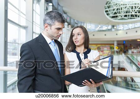 Businessman and woman discussing work View Large Photo Image Stock Photograph - Businessman and woman discussing work. Fotosearch
