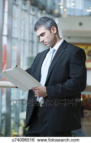 Businessman reading document View Large Photo Image Stock Photograph - Businessman reading document. Fotosearch