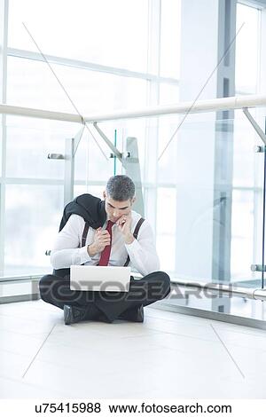 Businessman sitting on floor using laptop View Large Photo Image Stock Photo - Businessman sitting on floor using laptop. Fotosearch