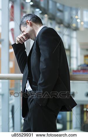 Businessman smirking and covering eyes View Large Photo Image Stock Image - Businessman smirking and covering eyes. Fotosearch