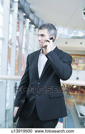 Businessman walking and talking on mobile phone View Large Photo Image Stock Image - Businessman walking and talking on mobile phone . Fotosearch