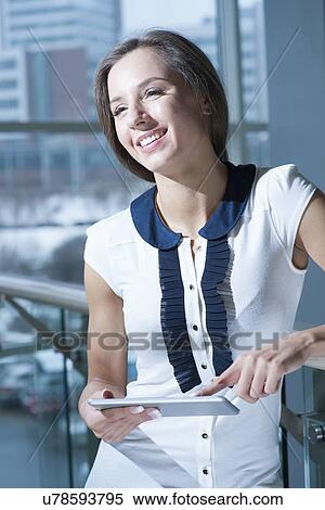 Businesswoman holding tablet device and smiling View Large Photo Image Stock Photography - Businesswoman holding tablet device and smiling. Fotosearch