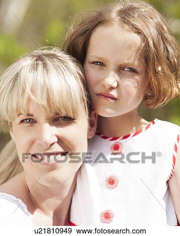Close-up head shot of mother and daughter embracing View Large Photo Image Stock Photo - Close-up head shot of mother and daughter embracing. Fotosearch