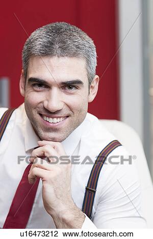 Stock Image - Close-up of businessman smiling at camera. Fotosearch