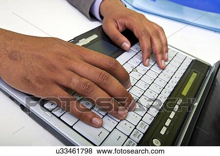Stock Photo - Close up of Indian mans hands typing on laptop. Fotosearch