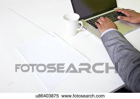 Stock Photography - Close up of Indian mans hands typing on laptop. Fotosearch