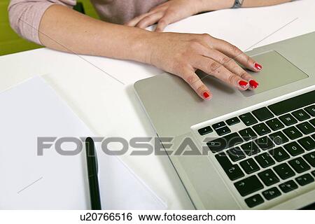 Stock Photograph - Close up of womans hands typing on laptop. Fotosearch