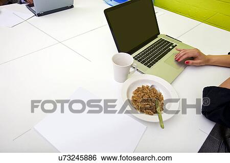 Close up of womans hands typing on laptop with mug in foreground View Large Photo Image Stock Photograph - Close up of womans hands typing on laptop with mug in foreground. Fotosearch