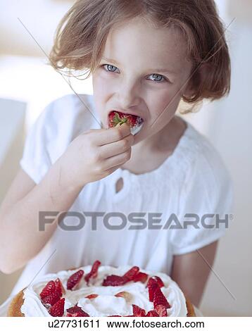 Close-up of Young girl with cake eating strawberry View Large Photo Image Stock Image - Close-up of Young girl with cake eating strawberry. Fotosearch