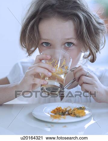 Stock Image - Close-up view of Young girl drinking cup of tea. Fotosearch