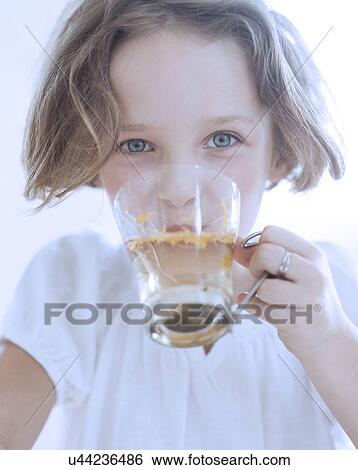 Stock Photograph - Close-up view of Young girl drinking cup of tea. Fotosearch