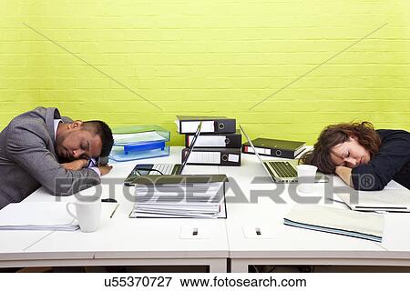 Stock Photo - Colleagues asleep at their respective desk. Fotosearch