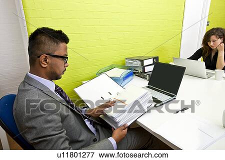 Colleagues working at their desks View Large Photo Image Stock Photo - Colleagues working at their desks. Fotosearch