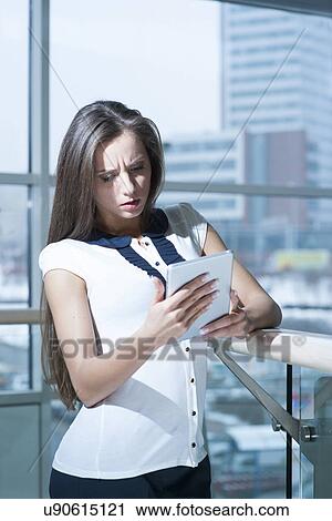 Concerned businesswoman looking at tablet device View Large Photo Image Stock Image - Concerned businesswoman looking at tablet device. Fotosearch