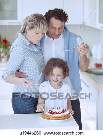 Stock Photograph - Family preparing healthy meal in kitchen. Fotosearch