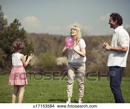 Picture - Family throwing ball to each other in the park. Fotosearch