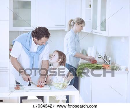 Father and Daughter looking at each other whilst preparing healthy meal in kitchen View Large Photo Image Stock Photo - Father and Daughter looking at each other whilst preparing healthy meal in kitchen. Fotosearch