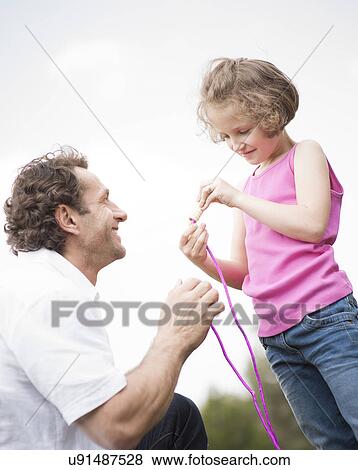 Stock Photo - Father and daughter together with skipping rope. Fotosearch