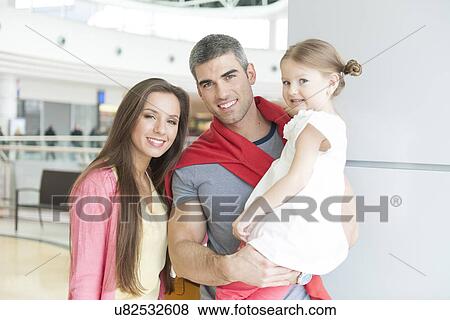 Father and mother pose with young daughter in shopping mall View Large Photo Image Stock Photo - Father and mother pose with young daughter in shopping mall. Fotosearch
