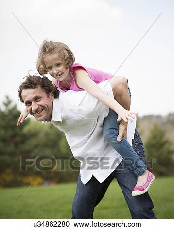 Father giving young daughter piggyback ride View Large Photo Image Stock Image - Father giving young daughter piggyback ride. Fotosearch