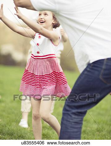 Father mother and daughter throwing ball to each other in the park View Large Photo Image Stock Photograph - Father mother and daughter throwing ball to each other in the park. Fotosearch