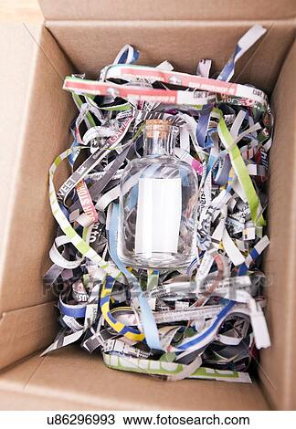 Stock Image - Glass bottle wrapped in a box. Fotosearch